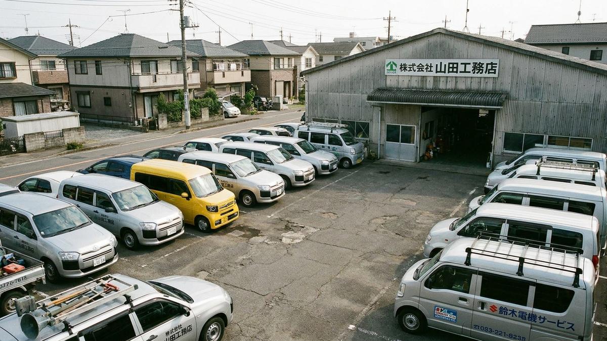 法人所有の複数台営業車が並ぶ駐車場
